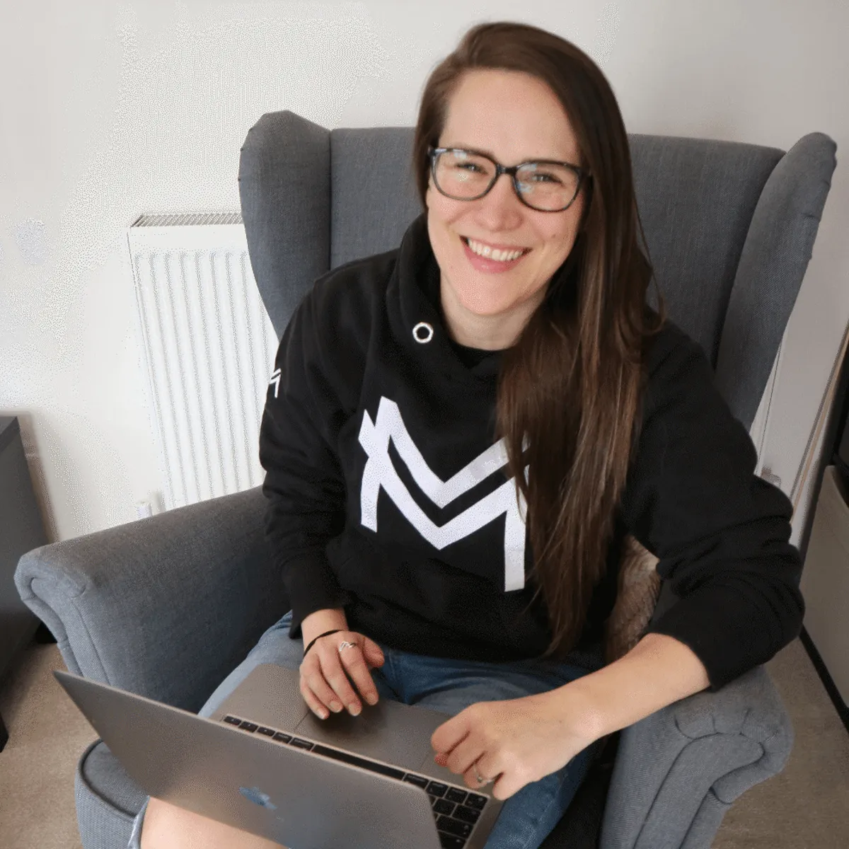 Ash smiling on a chair and laptop