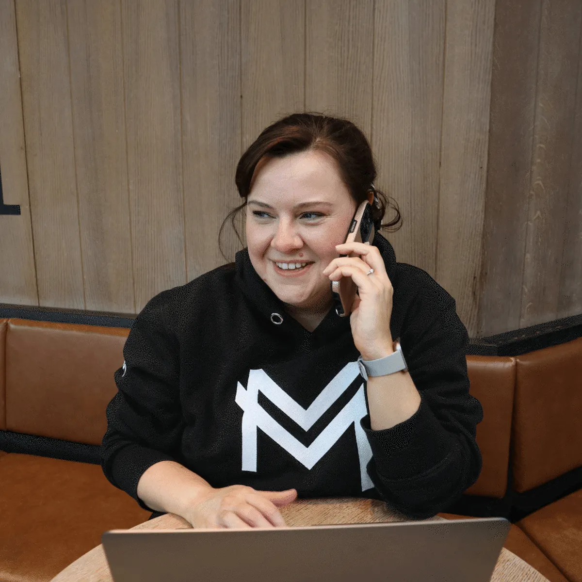 Han talking on phone and working on laptop